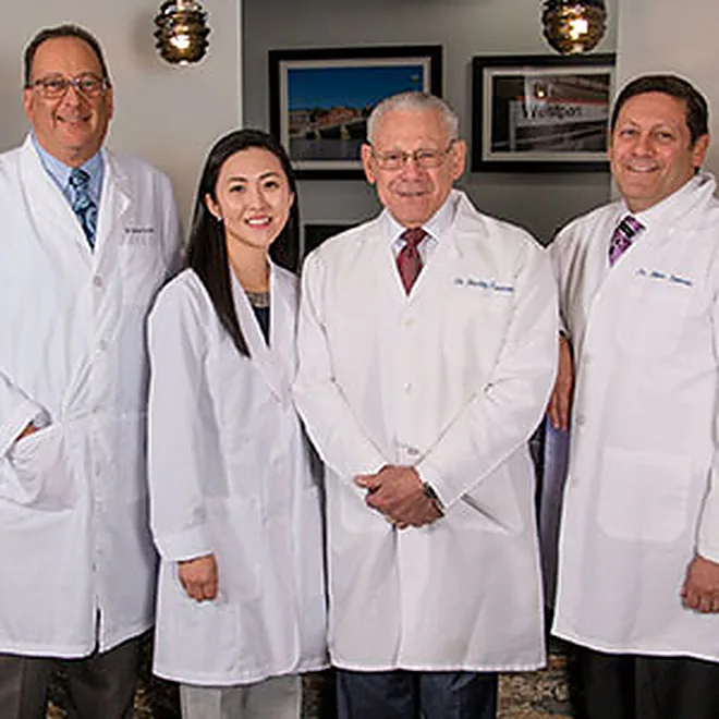 Four of the dentists of Westport Dental Associates in the practice corridor.